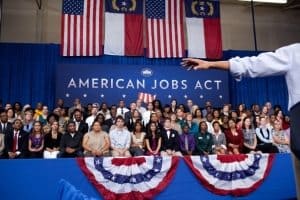 People Listen to President Barack Obama as he delivers remarks on the American Jobs Act 2012