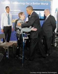 U.S. President Obama hugs U.S. Army Sergeant Hannigan as she wears an electronic leg technology named ReWalk during a tour of the technology expo in Jerusalem