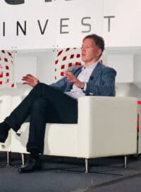 Crowdfund insider conference speaker discussing investment strategies on stage at a fintech event.