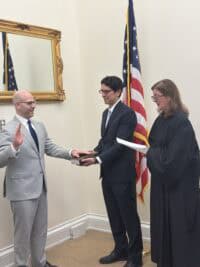 Certificate presentation at a crowdfunding legal or financial ceremony, featuring professionals in formal attire with US flags in the background, highlighting crowdfunding industry standards and compliance.